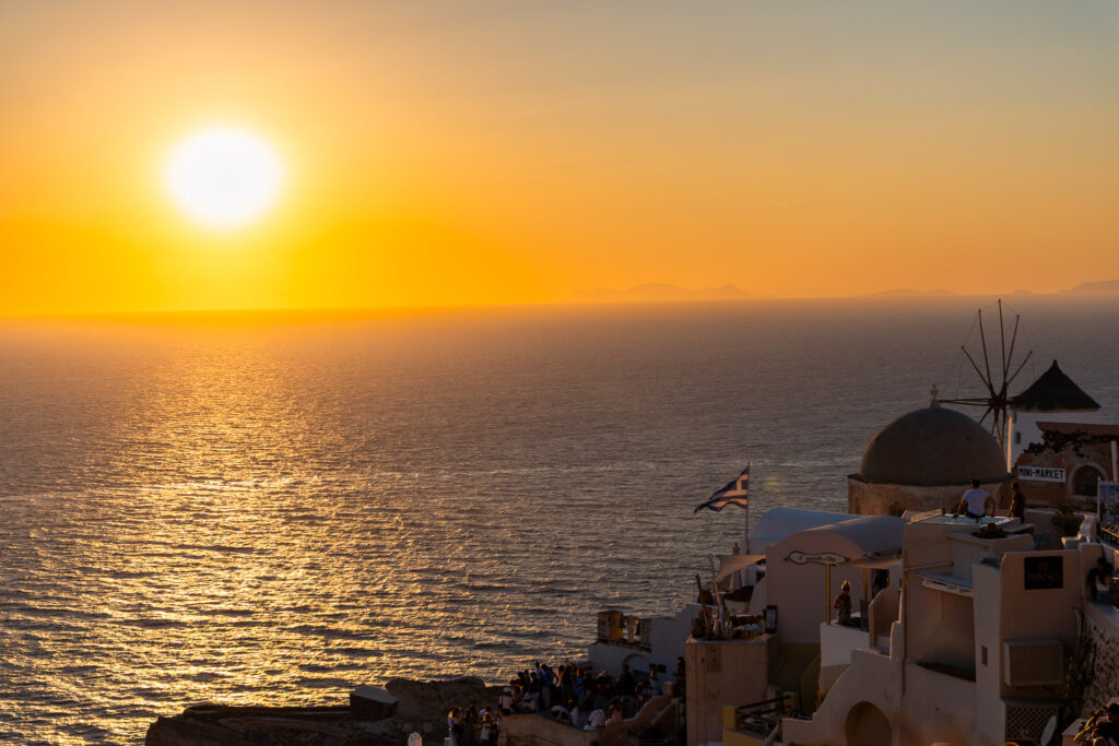 Pôr do sol em Santorini com vista para o mar Egeu e construções típicas em Oia
